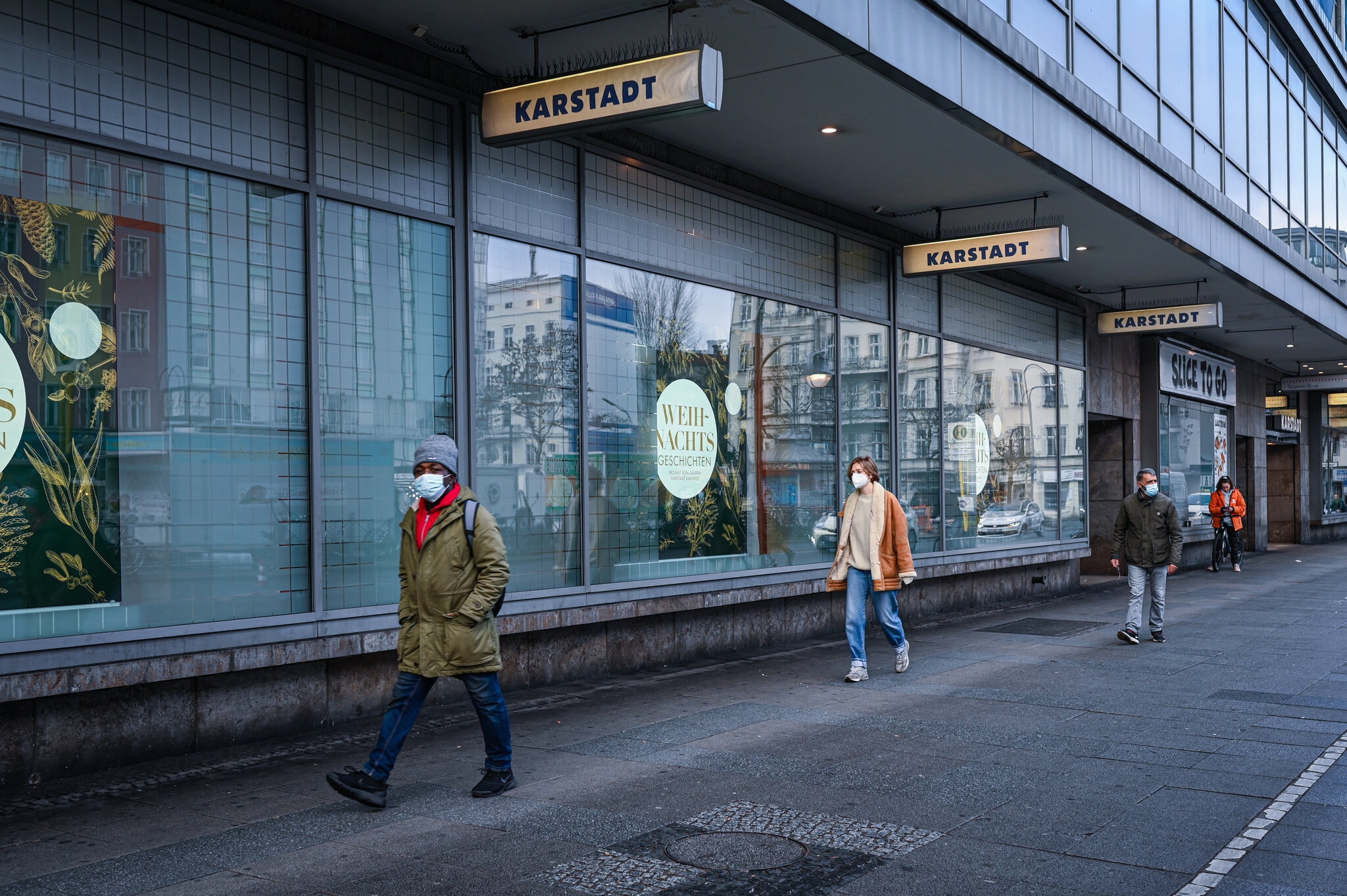 Người dân đi bộ bên ngoài các cửa hàng bị đóng ở Berlin. Ảnh: NY Times