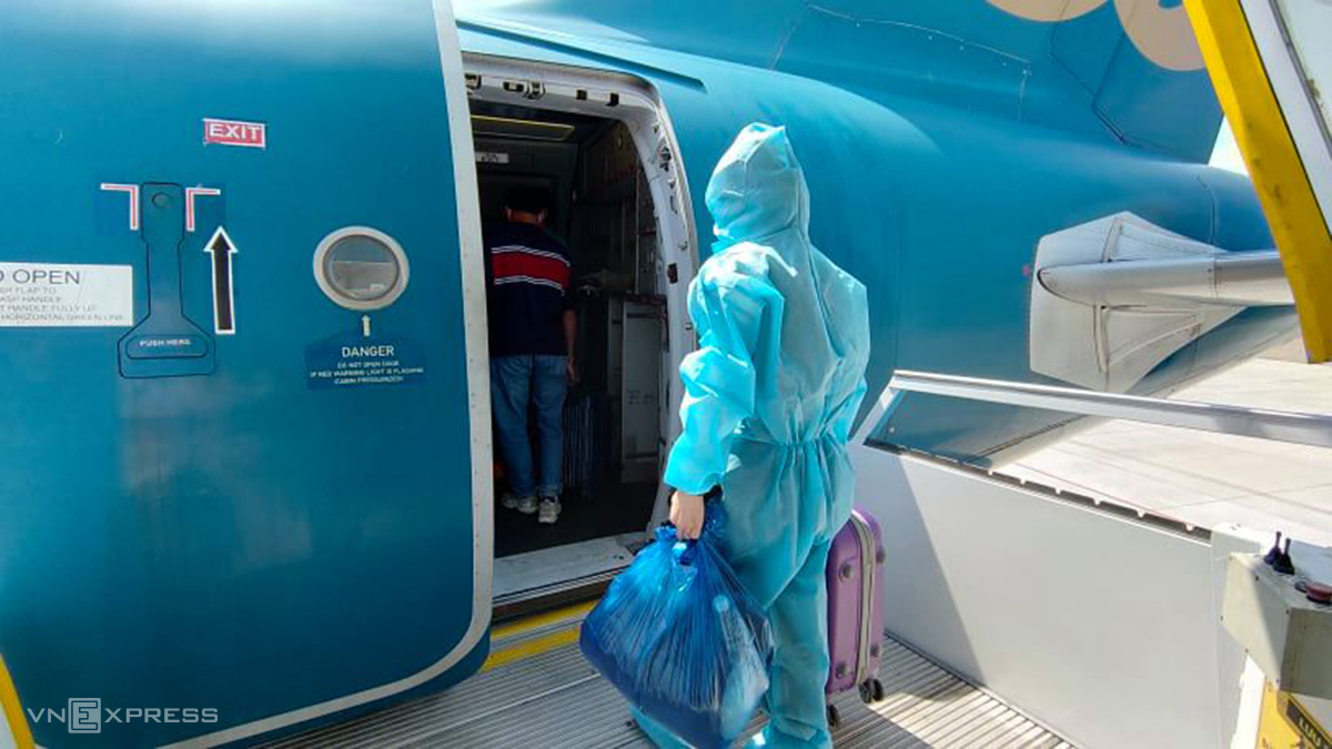 Một hành khách mặc đồ bảo hộ bước vào máy bay Vietnam Airlines, chuyến bay trưa 9/2. Ảnh: Cao Hà.