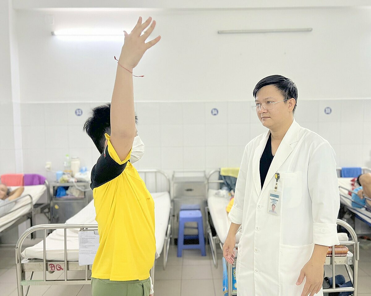 Bác sĩ thăm khám cho bé trai trong quá trình tập phục hồi chức năng. Ảnh: Phương Em